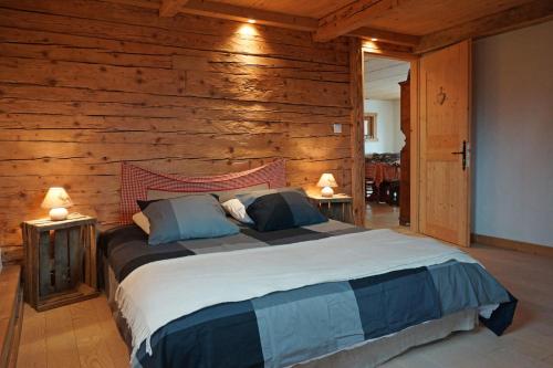 サン・ジャン・ド・シックスにあるLes chalets du Rosayの木製の壁に大きなベッドが備わるベッドルーム1室