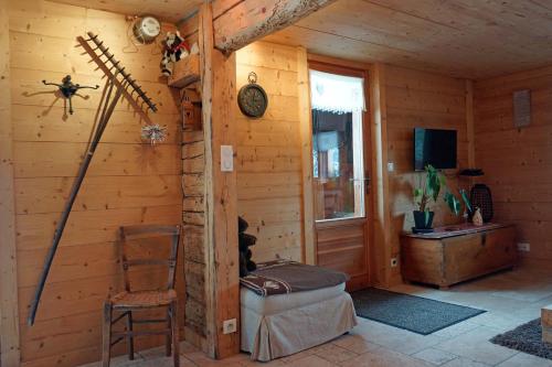 Cette chambre se trouve dans une cabane en bois avec une chaise. dans l'établissement Les chalets du Rosay, à Saint-Jean-de-Sixt