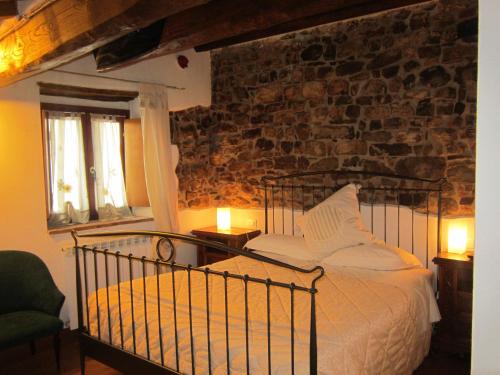 a bedroom with a bed and a stone wall at Castello di Civitella in Civitella in Val di Chiana