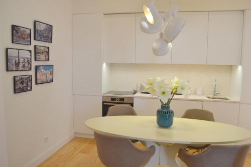 a kitchen with a table with a vase of flowers on it at TP AURA 19, Swimming Pool, Terrace & View in Lisbon