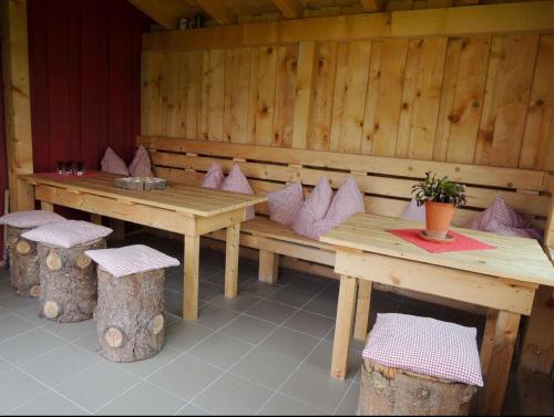 a wooden table and bench with a table and two stools at Ferienwohnungen Hackl Ulrike in Mauth