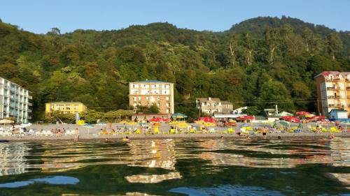 a beach with a crowd of people and buildings at Hotel Kvariati Nugo in Kvariati