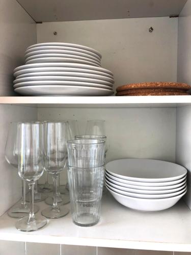a white shelf with plates and glasses on it at Apartment Newstyle in Regensburg