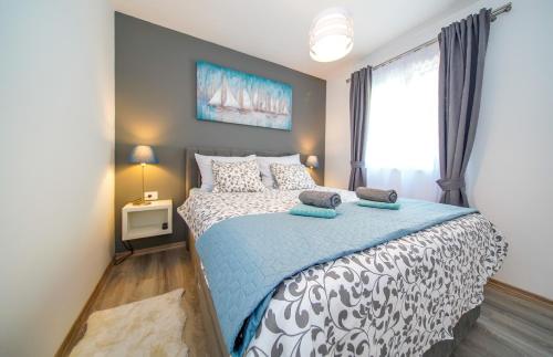 Schlafzimmer mit einem Bett mit einer blauen und weißen Bettdecke in der Unterkunft Apartmani Ponta in Ston