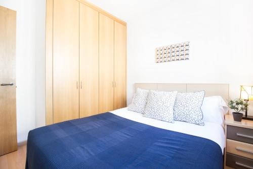 a bedroom with a blue and white bed and cabinets at Apartaments Les Terrasses del Tarter in El Tarter