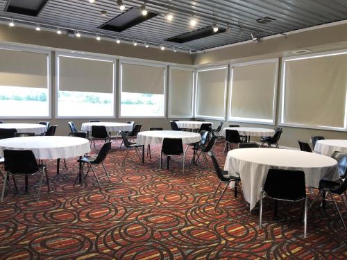 a conference room with tables and chairs and windows at HomeTown Inn and Suites Belle Plaine in Belle Plaine