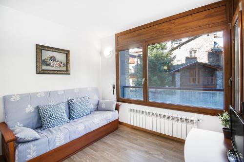 a living room with a couch and a window at Apartaments Les Terrasses del Tarter in El Tarter