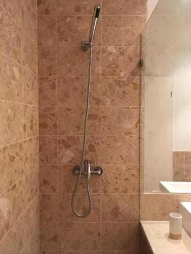 a shower with a shower head in a bathroom at Sea view - top floor in Quarteira
