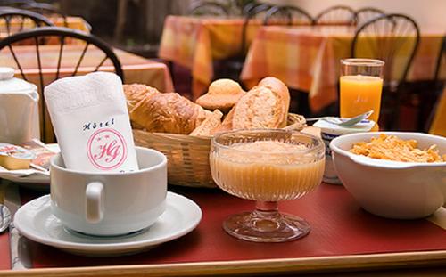 a table with a tray of bread and a cup of coffee at Hôtel Icare in Toulouse