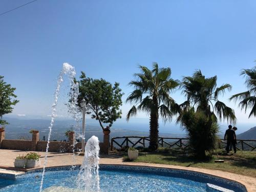 a fountain in a pool with a view of the ocean at Hotel Bucolia in Lamezia Terme