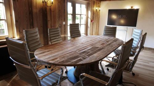 a conference room with a wooden table and chairs at Le Tillau in Les Verrières-de-Joux