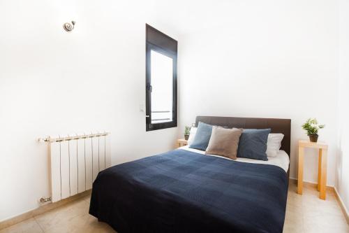 una camera con un letto e una coperta blu di Apartaments Les Terrasses del Tarter a El Tarter