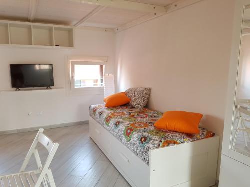 1 dormitorio con 1 cama con almohadas de color naranja en Mansarda Settimo Cielo en Chioggia