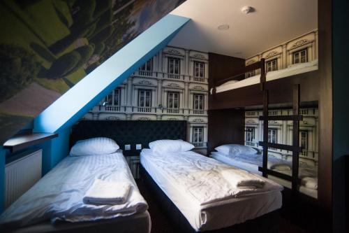 two beds in a room with a blue beam at World Hostel - Old Town in Gdańsk