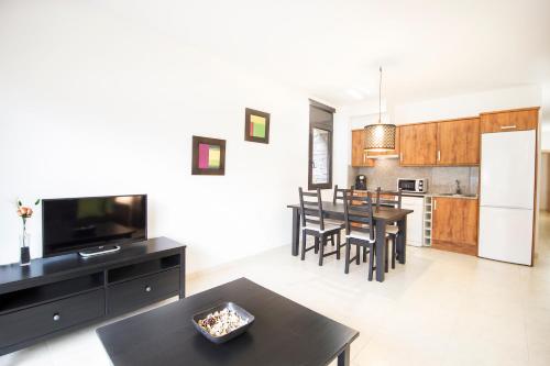 a kitchen and living room with a table and a refrigerator at Apartaments Les Terrasses del Tarter in El Tarter