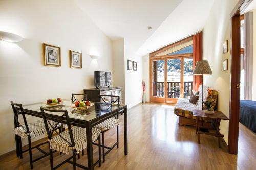 a living room with a dining room table and chairs at Apartaments Les Terrasses del Tarter in El Tarter