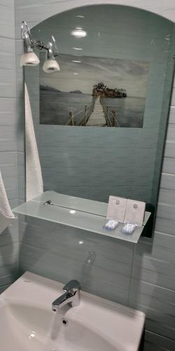 a white bathroom with a sink and a mirror at Къща за гости Гаджакови in Devin