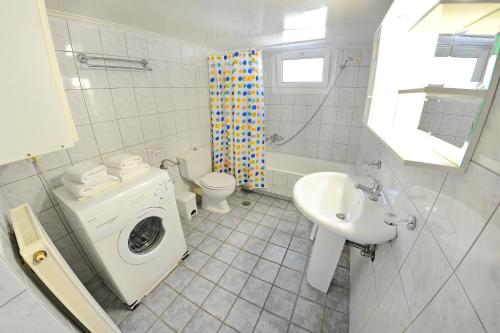 a bathroom with a washing machine and a sink at Korakias Skorpidi in Yénion