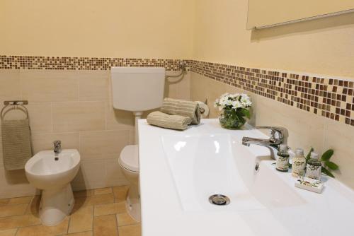 a bathroom with a white sink and a toilet at PienzaLettings "Casa Olivieri" in Pienza