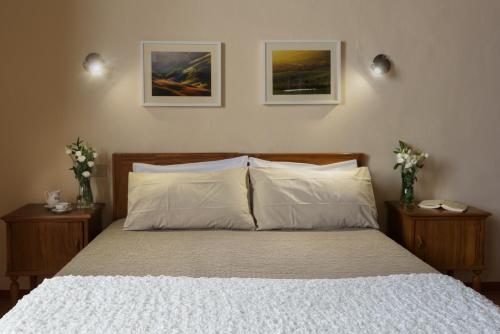 a bedroom with a bed with two vases of flowers at PienzaLettings "Casa Olivieri" in Pienza