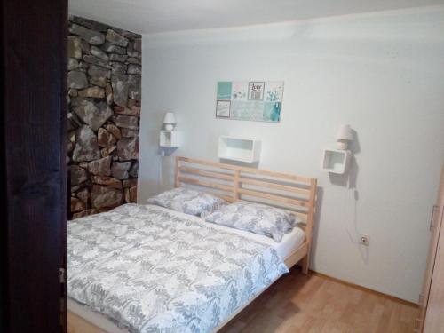 a bedroom with a bed and a stone wall at Zelena Oaza Mira Bribir in Bribir
