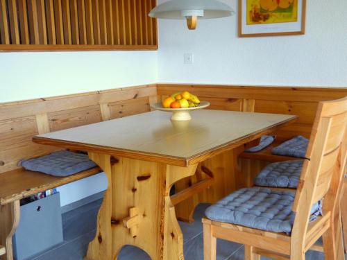 a wooden table with a bowl of fruit on it at Wallisblick in Blatten bei Naters