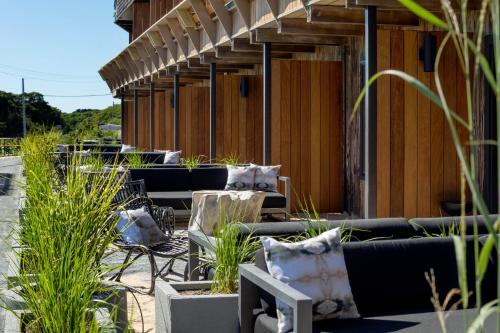an outdoor patio with couches and chairs and plants at AWOL Hotel Provincetown in Provincetown