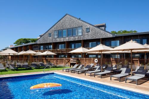a hotel with a swimming pool with chairs and umbrellas at AWOL Hotel Provincetown in Provincetown