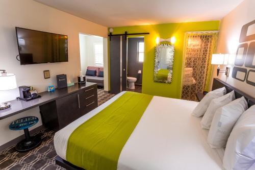 um quarto de hotel com uma cama grande e uma televisão em University Inn ASU/Tempe em Tempe