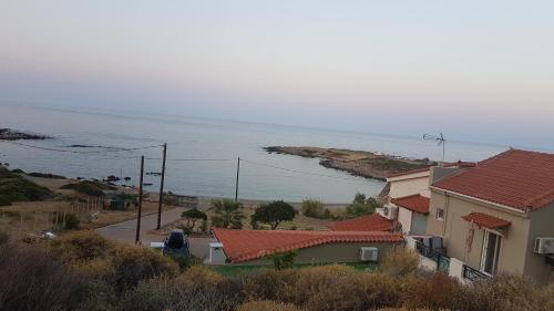 a view of a house and the ocean at Anatoli Studios in Áyios Fokás