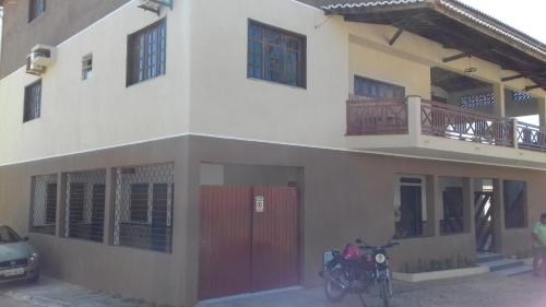 a house with a motorcycle parked in front of it at Pousada do Holandês in Canoa Quebrada