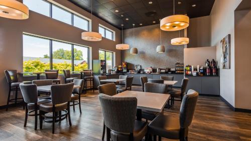 a restaurant with tables and chairs and a bar at Best Western New Oregon Motel in Eugene
