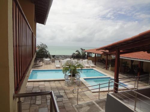 a swimming pool with a view of the ocean at Laina´s Place Hotel in Natal