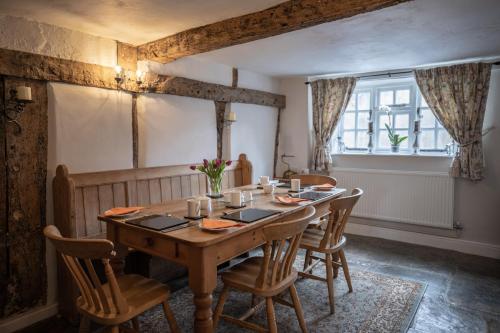 een eetkamer met een houten tafel en stoelen bij Old Beams Bed & Breakfast in Alcester