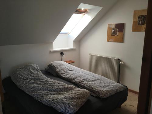 a bed in a small room with a skylight at Nordly ferielejlighed in Billum