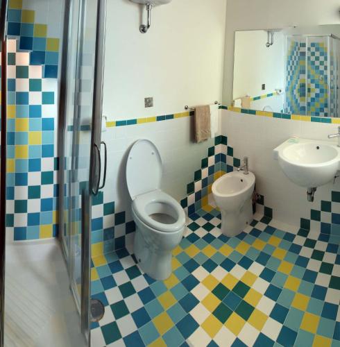 a bathroom with a toilet and a sink at Giulivo Hotel & Village in Baia Domizia