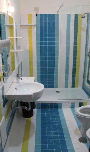 a bathroom with a sink and a shower and a toilet at Giulivo Hotel & Village in Baia Domizia