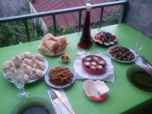 a green table with plates of food on it at Best Host in Sighnaghi