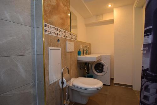 a bathroom with a toilet and a washing machine at Apartment Terrotstraße in Stuttgart