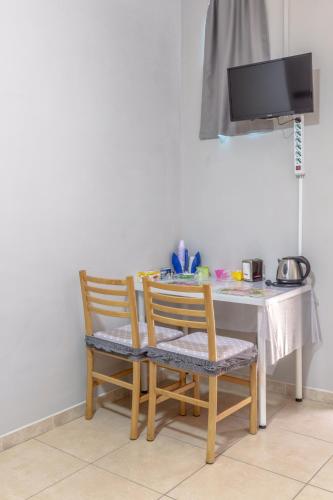 a dining room table with two chairs and a television at Tufaro B&B Private Room in Macerata Campania