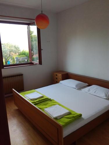 a bedroom with a bed with a green blanket on it at Apartment Jasmine in Izola
