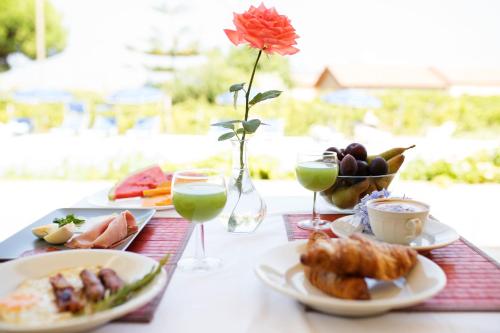 een tafel met borden met eten en glazen wijn bij B&B Il Cavaliere Tropea in Santa Domenica