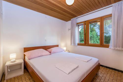 um quarto com uma grande cama branca e uma janela em Villa Lahor with private pool em Seget Vranjica