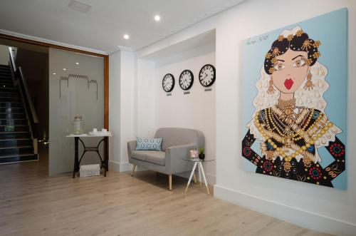 a living room with a painting of a woman on a wall at Hotel Puerta Ciudad Rodrigo in Ciudad-Rodrigo