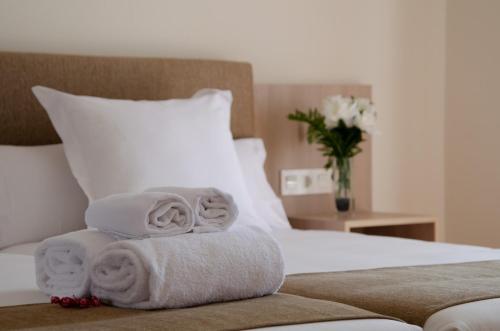a pile of towels sitting on top of a bed at Hotel Puerta Ciudad Rodrigo in Ciudad-Rodrigo