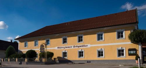 a large yellow building with a brown roof at Gästehaus Stögmüller in Asten