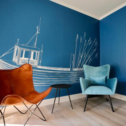 a room with a blue wall with a boat mural at Hotel Boje06 in Heringsdorf