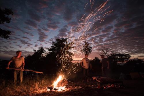 a group of people standing around a bonfire at Havana Lodge in Mal País