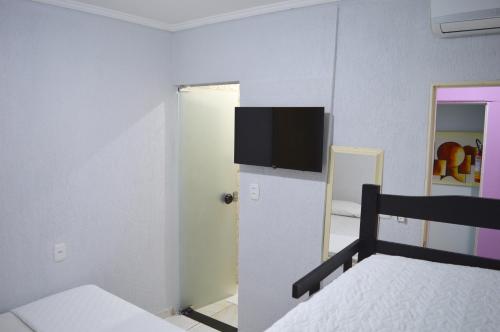 a bedroom with a bed and a tv on the wall at Hostel Prime in Rio Verde