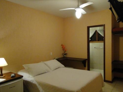 a bedroom with a bed and a ceiling fan at Pousada Jardim Comary in Teresópolis